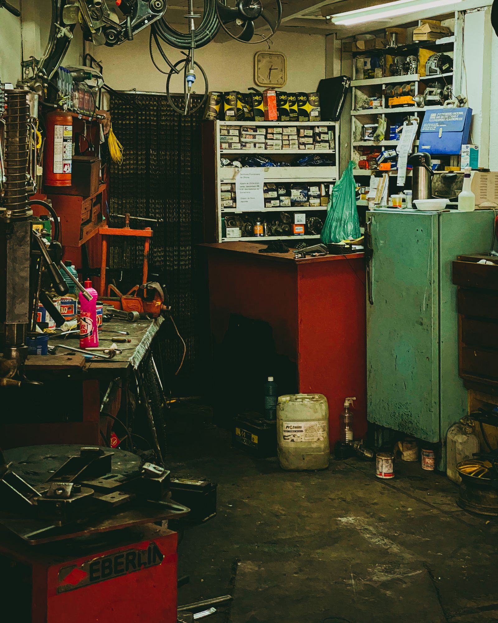 A cluttered workshop packed with tools, cans and shelving