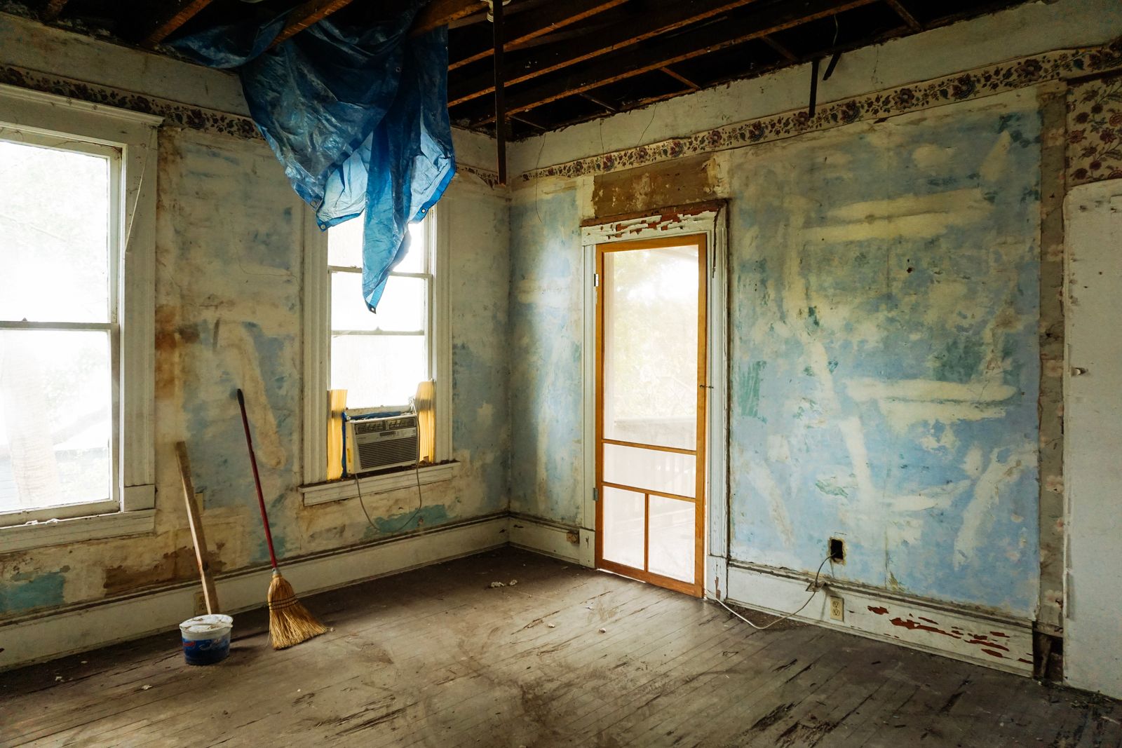 An empty room with a broom and bucket after a clear-out